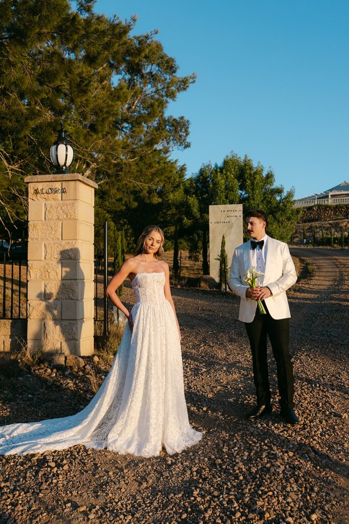editorial photography of couple standing next to alora macedon driveway entrance