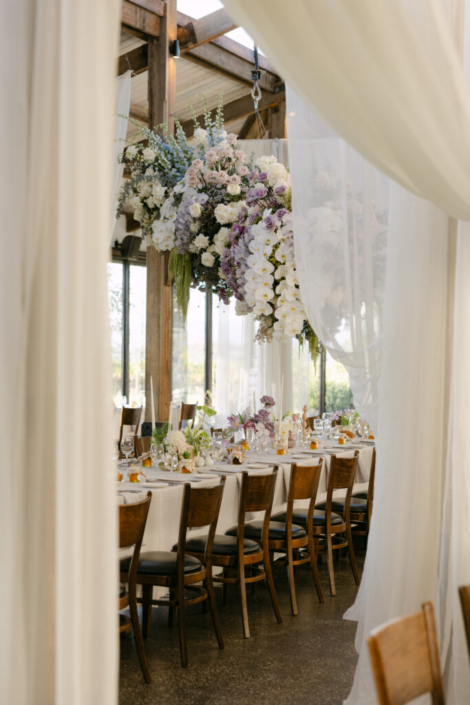 indoor wedding reception setup at stones of the yarra valley with hanging floral installation