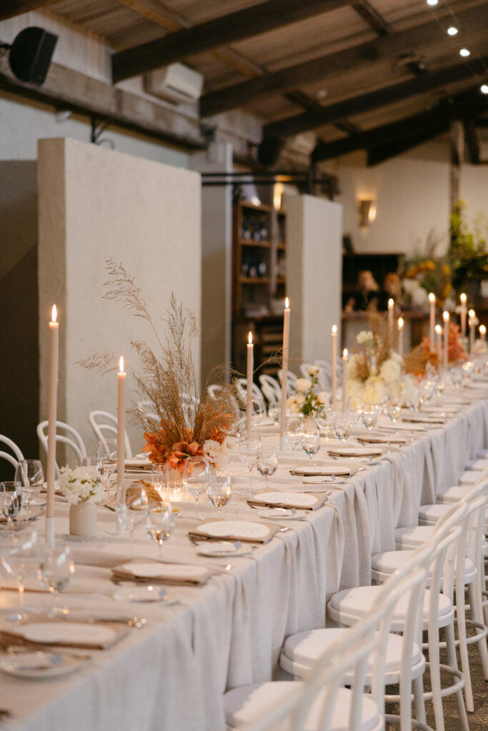 wedding reception table styling with cathedral candles and white chairs at stones of the yarra valley
