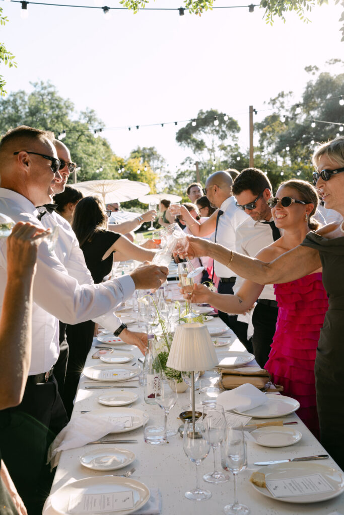 candid portrait of guests cheering during outdoor reception at woolbrook homestead