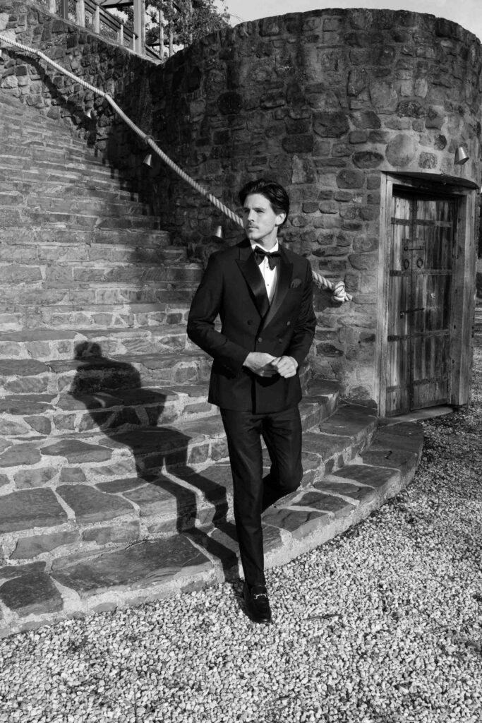 editorial black and white portrait of groom walking down the stairs at Feathertop Winery