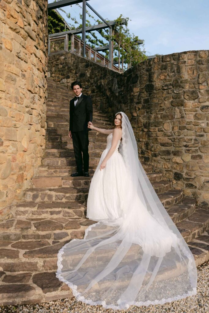couple posing on the tuscan inspired cobblestone stairs at Feathertop Winery 