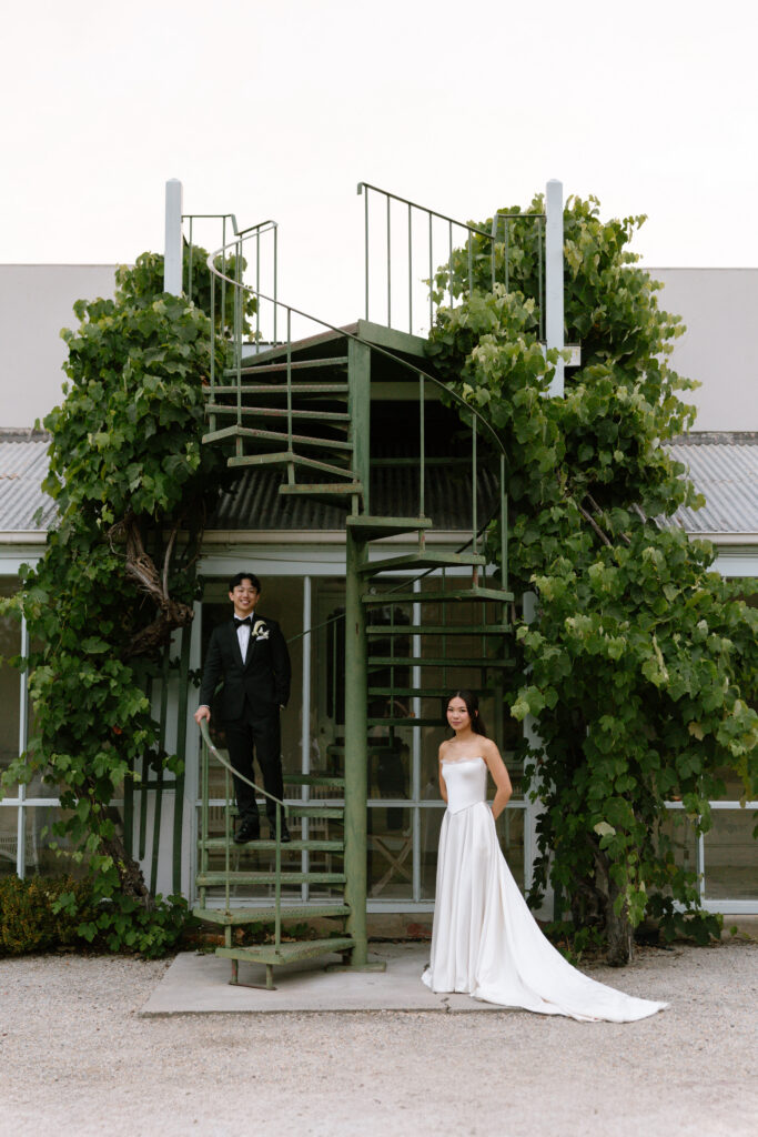 couple posing with green spiral staircase at Coombe Yarra Valley wedding venue