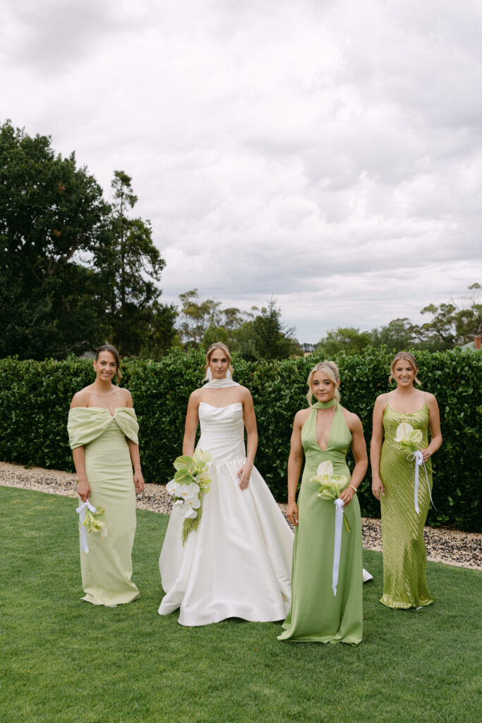 bride with bridesmaids wearing green tonal dresses at Barunah Plains wedding venue